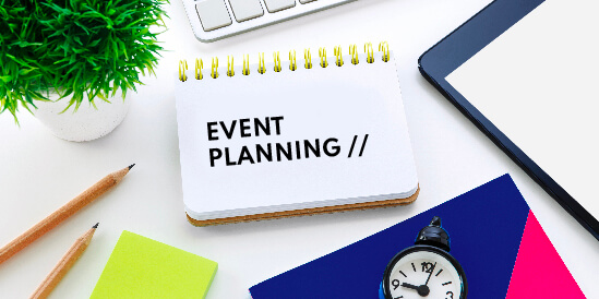 Event planning written on a calendar surrounded by note books