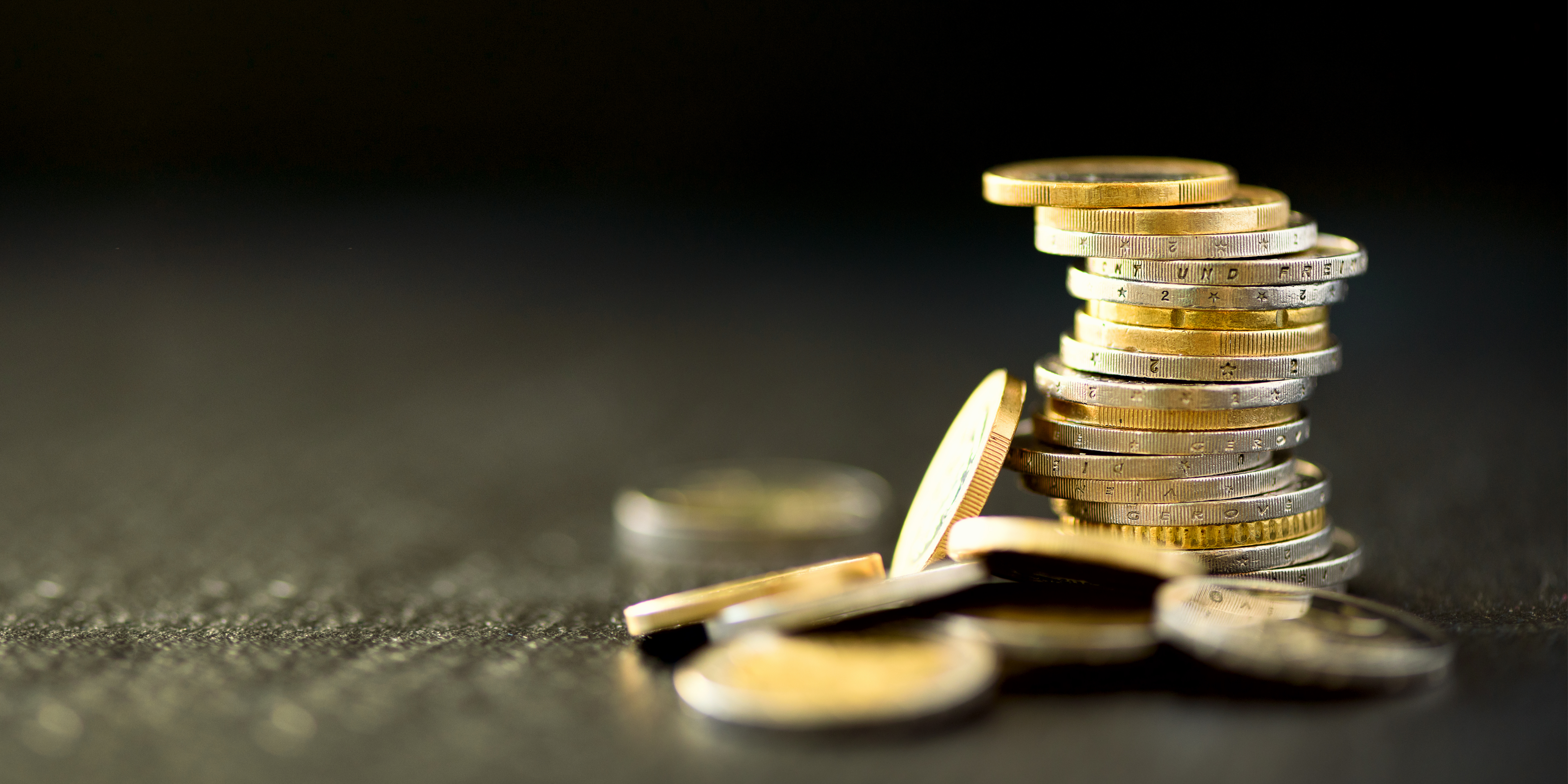 A pile of coins with a dark background, symbolising society grants