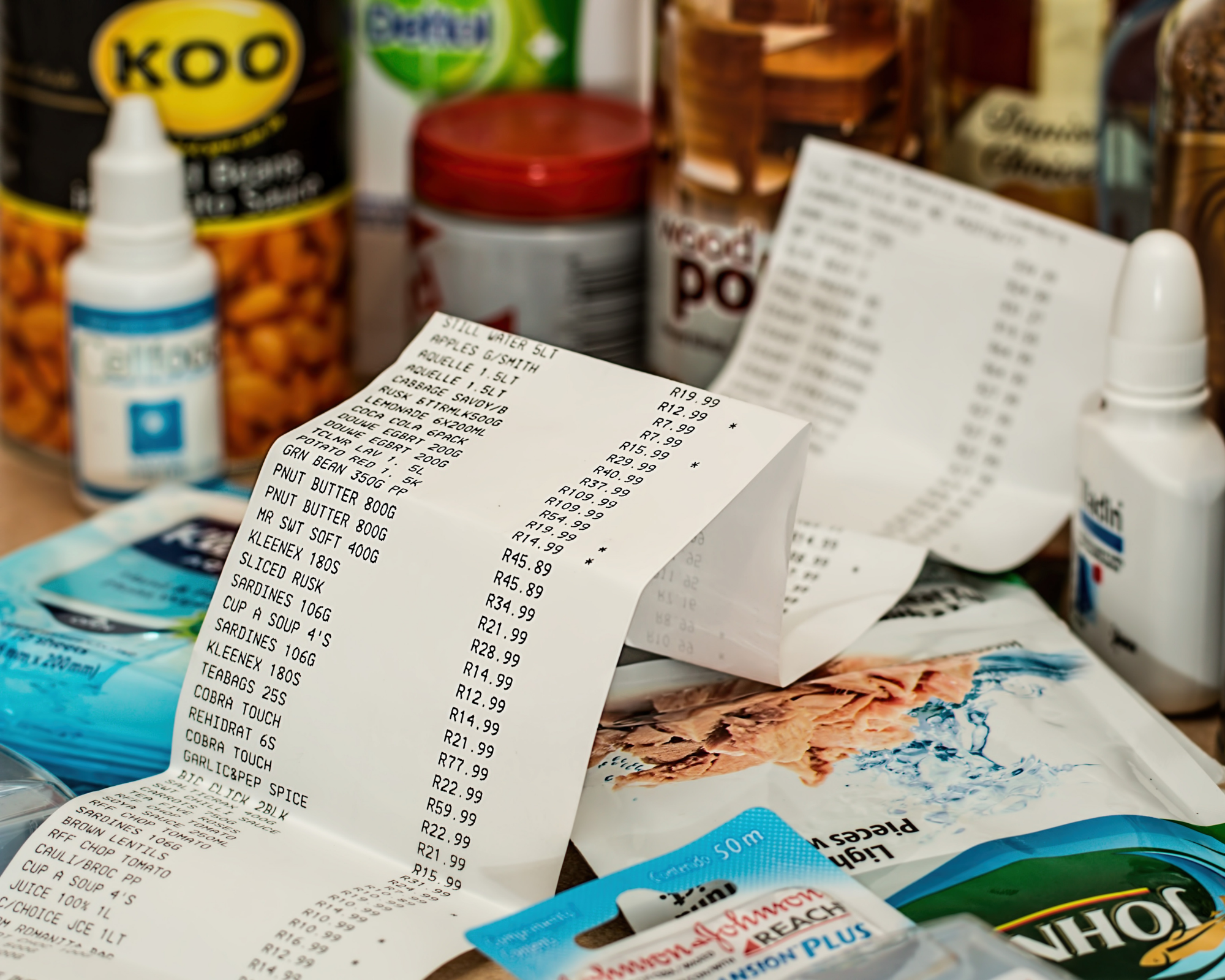 Image of a long printed receipt surrounded by various groceries.