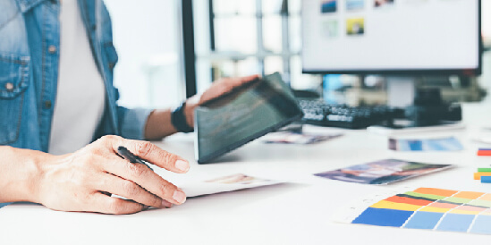 Student with computer and paper writing their marketing strategy