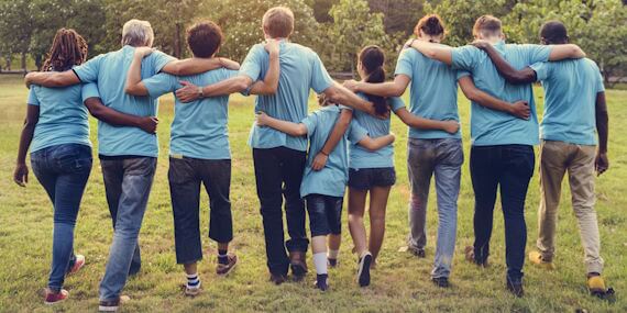 Group of students walking off together with arm over shoulders