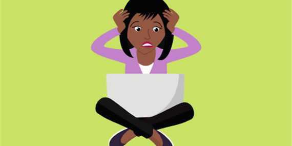 Woman sitting with laptop, holding head in her hands