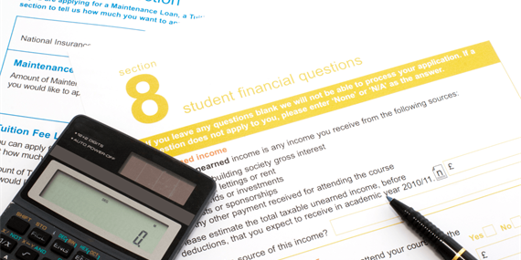 Student Finance application form with calculator and pen