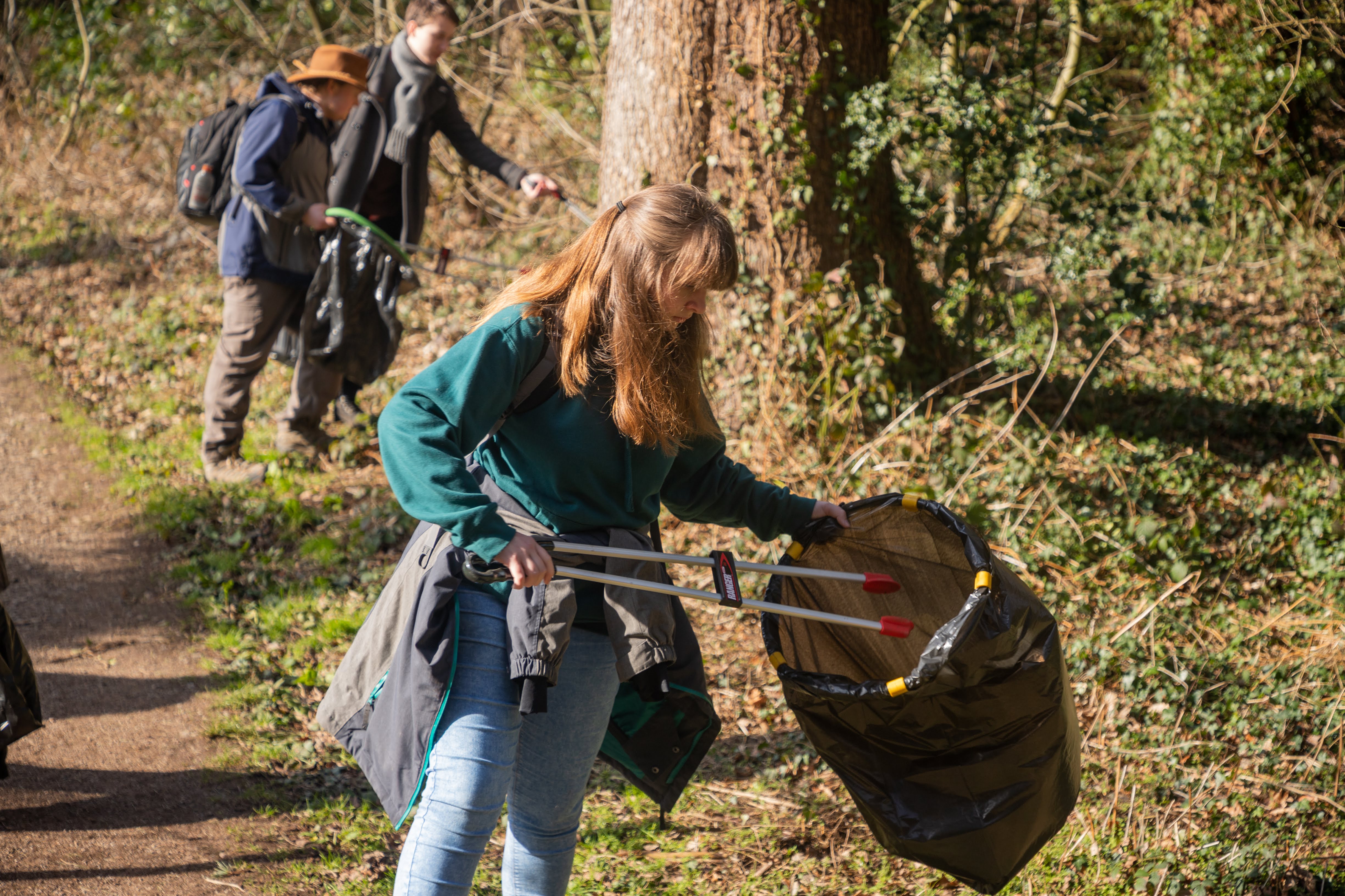 Students litter picking in the woods on campus